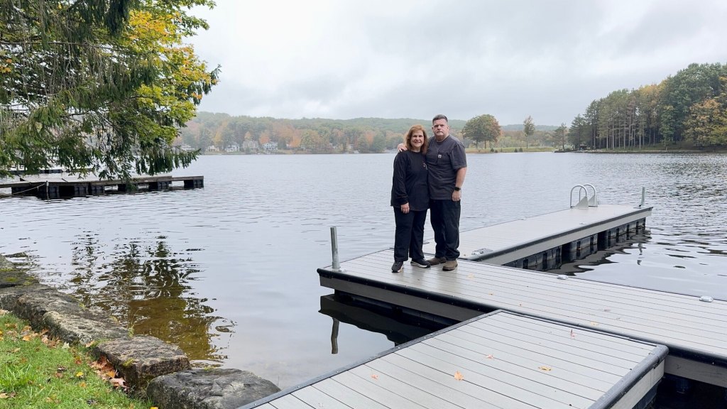 Corey and Katy standing together on the dock at Treasure Lake on a cloudy fall morning