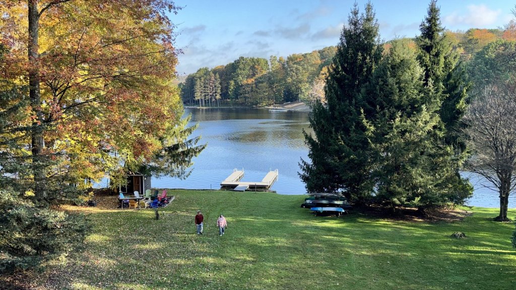 Corilee and Grant walking up the lawn from the lake on a sunny fall morning