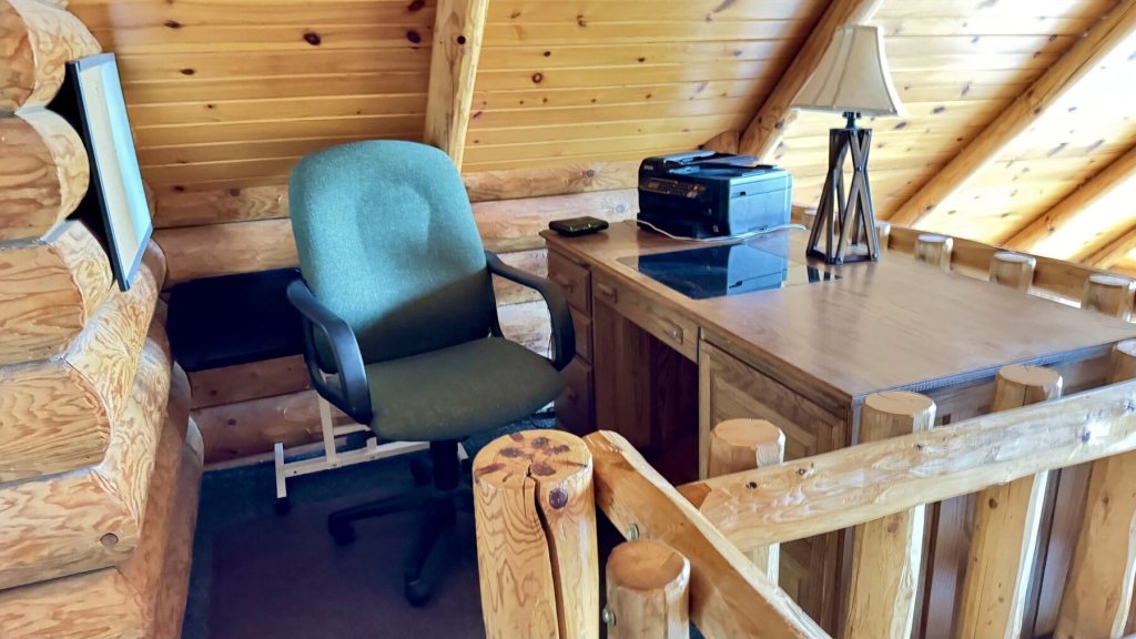 Desk and chair in the loft under the sloped pine ceiling