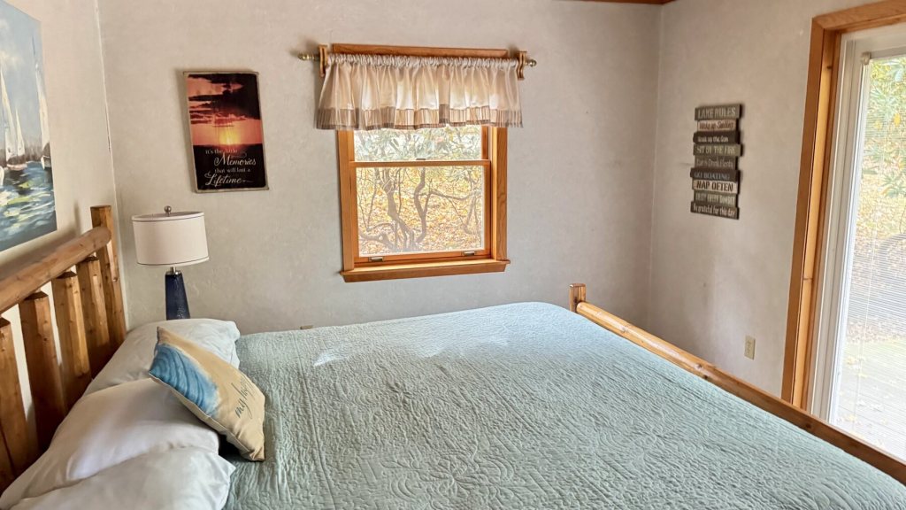 Bedroom with a large bed, a window and a door to the deck