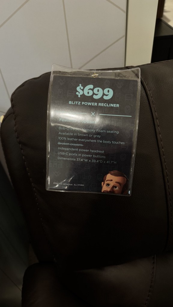 Price tag on a brown leather power recliner at Bob's Discount Furniture, showing the Blitz Power Recliner at $699