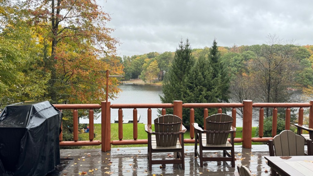 Covered grill and chairs on the cabin deck with Treasure Lake behind
