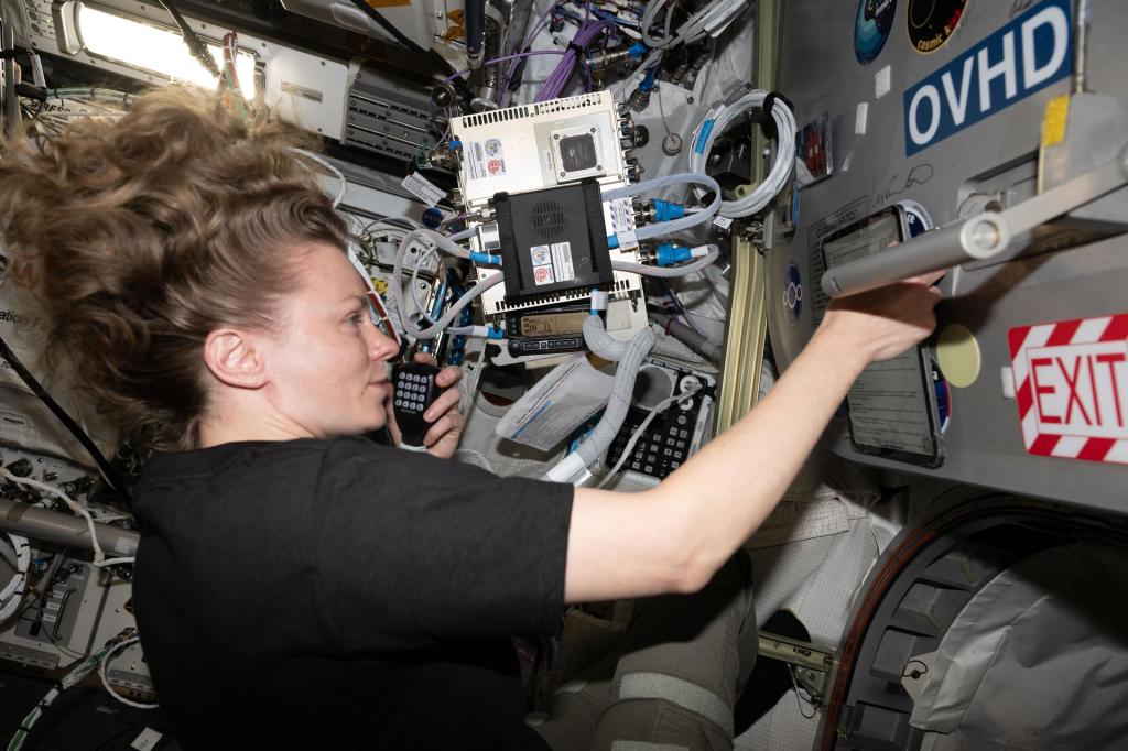 NASA astronaut Zena Cardman speaking into a ham radio microphone aboard the International Space Station